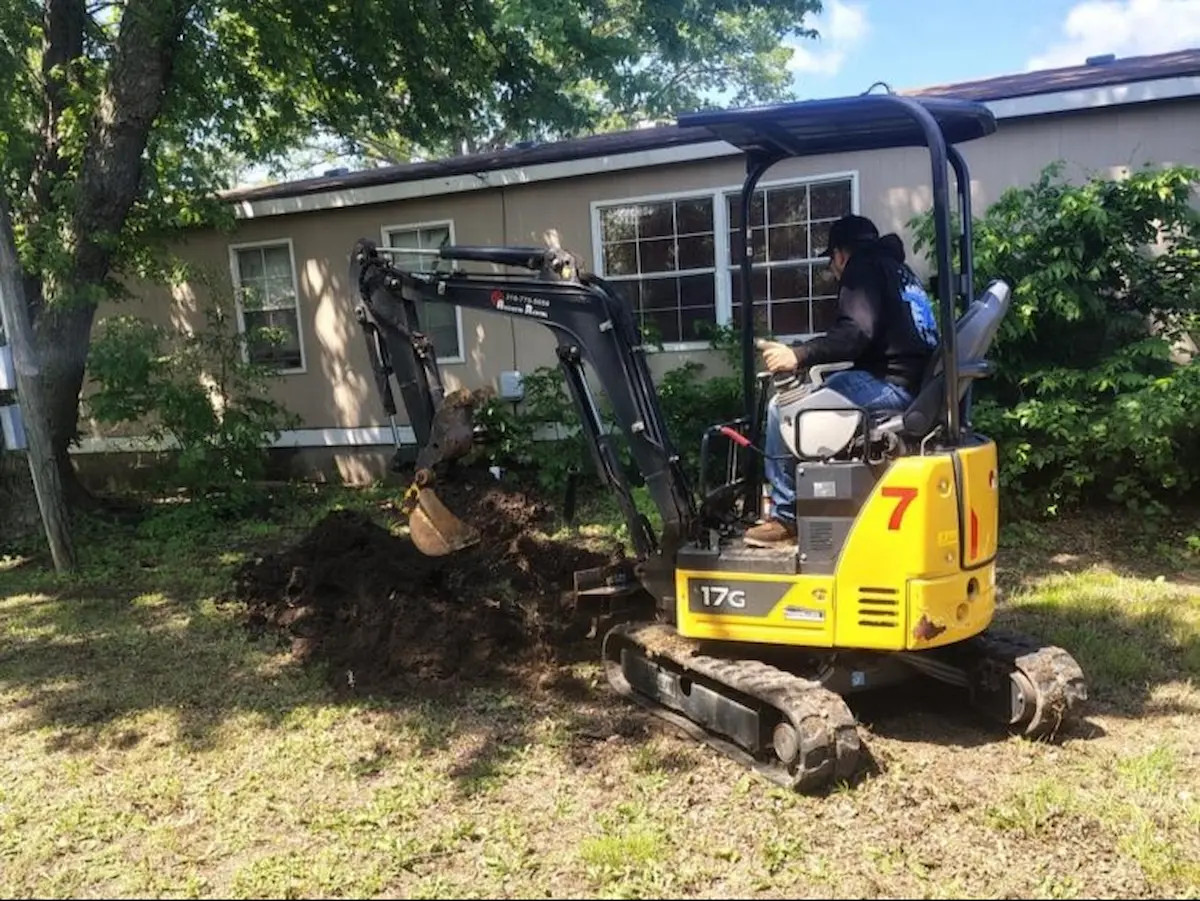 Mini excavator digging for a water service line repair in Butler County, Kansas