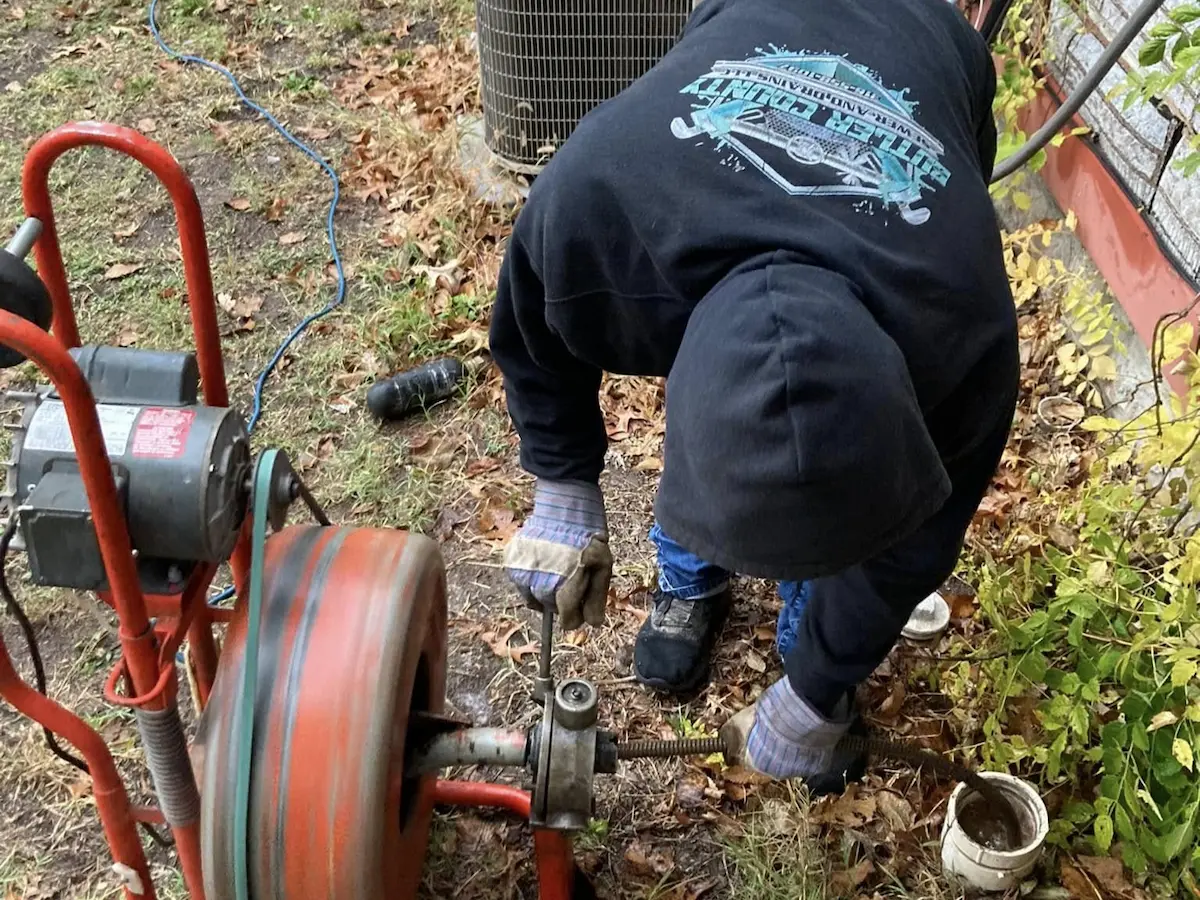 Technician performing sewer cleaning at an outdoor cleanout in Butler County, KS